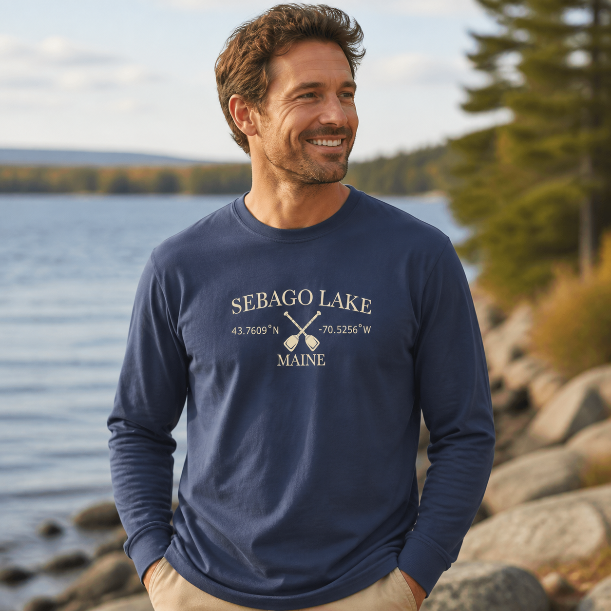 Male model wearing the navy Sebago Lake coordinates and paddles long-sleeve shirt by the lake