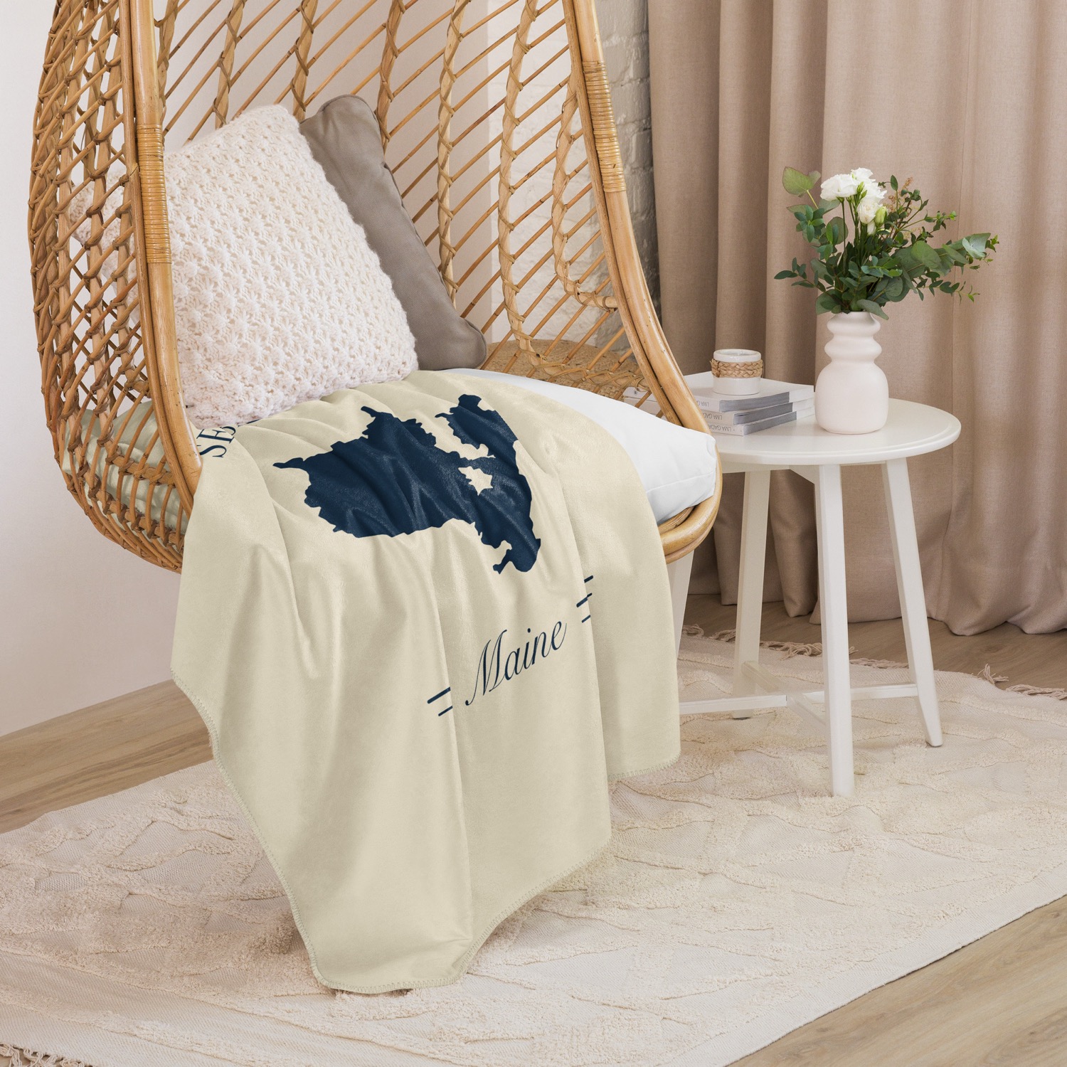 Sebago Lake map sherpa blanket draped over a cozy wicker chair