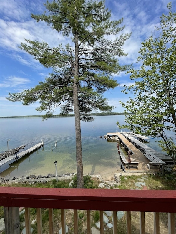 A lakeside view with a dock extending into the water, surrounded by trees.